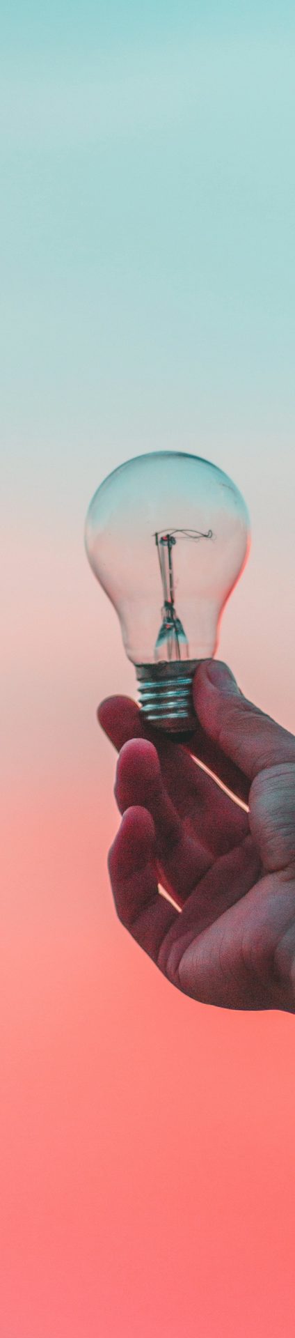 Glühbirne in der Hand; Quelle: Strato hp-Baukasten Eine Hand hält eine Glühbirne vor einem sanften, farbverlaufenden Hintergrund.